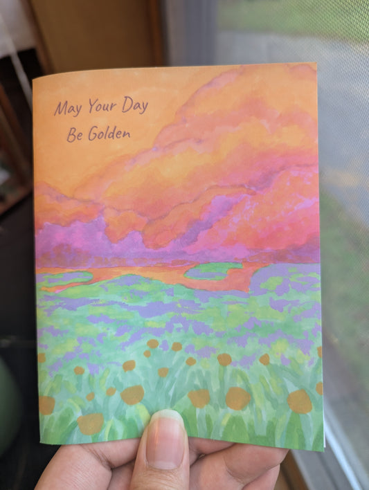 4.25x5.5 Christian birthday card with an original painting of a golden sunset over a meadow of golden flowers, "May Your Day Be Golden" on the front